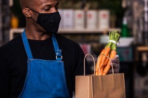 A male Black worker bags groceries. (Photo by Matthew Henry from Burst)
